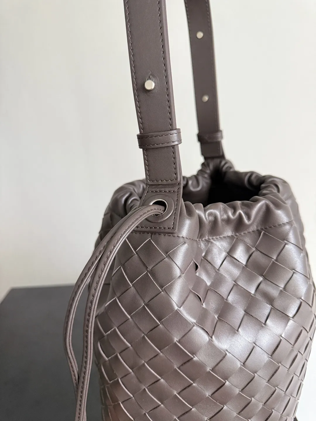 Batch 2280 BOTTEGA VENETA2025 new woven Biblioteca Bucket perfectly integrates casual texture, using classic Intrecciato woven leather, which feels soft but stiff, allowing the bag to drape naturally without losing the three-dimensional effect. The drawstring design of the drawstring pocket makes opening and closing more direct and adds a casual atmosphere. If you are on a short business trip, you can put some skin care samples in your bag. The front compartment or rear zipper can also be used to store ID cards, bank cards, etc. The solid color design of the bag is very versatile, and it doesn’t feel too picky when paired with any clothes. The leather material is also very high-quality! Style number: 836020 Size: 24*33*14cm